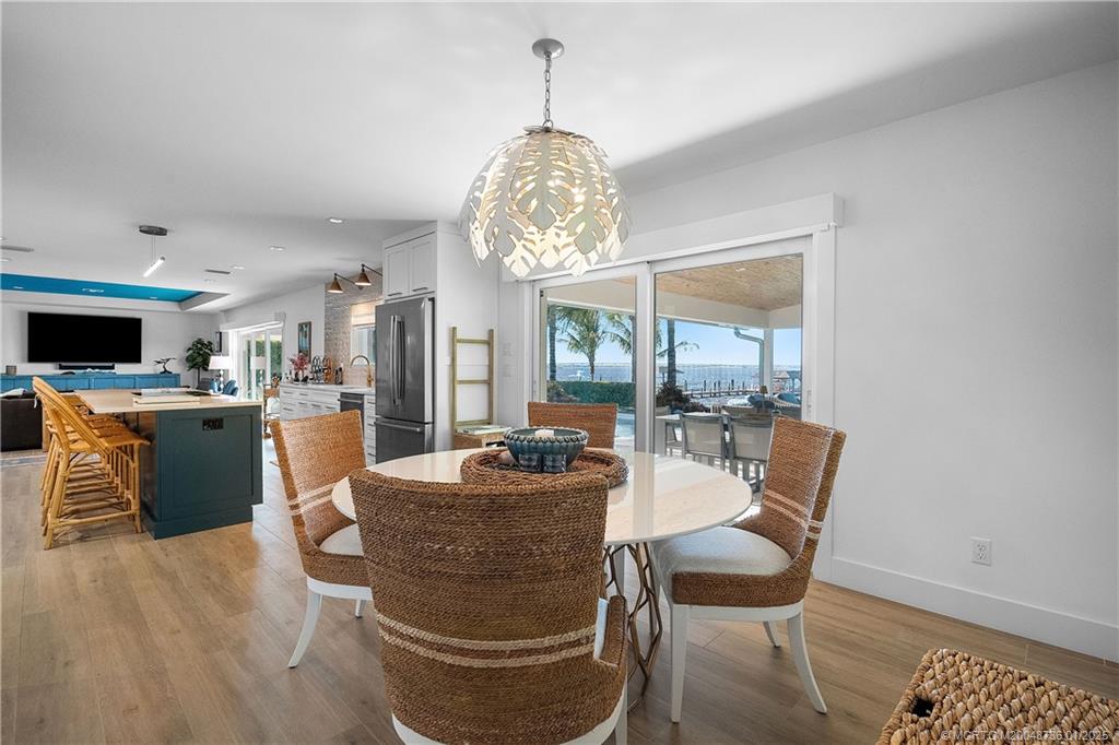 1433 Southeast Riverside Drive Stuart, FL 34996 - Photo 16 of 64 a dining room with furniture a chandelier and wooden floor