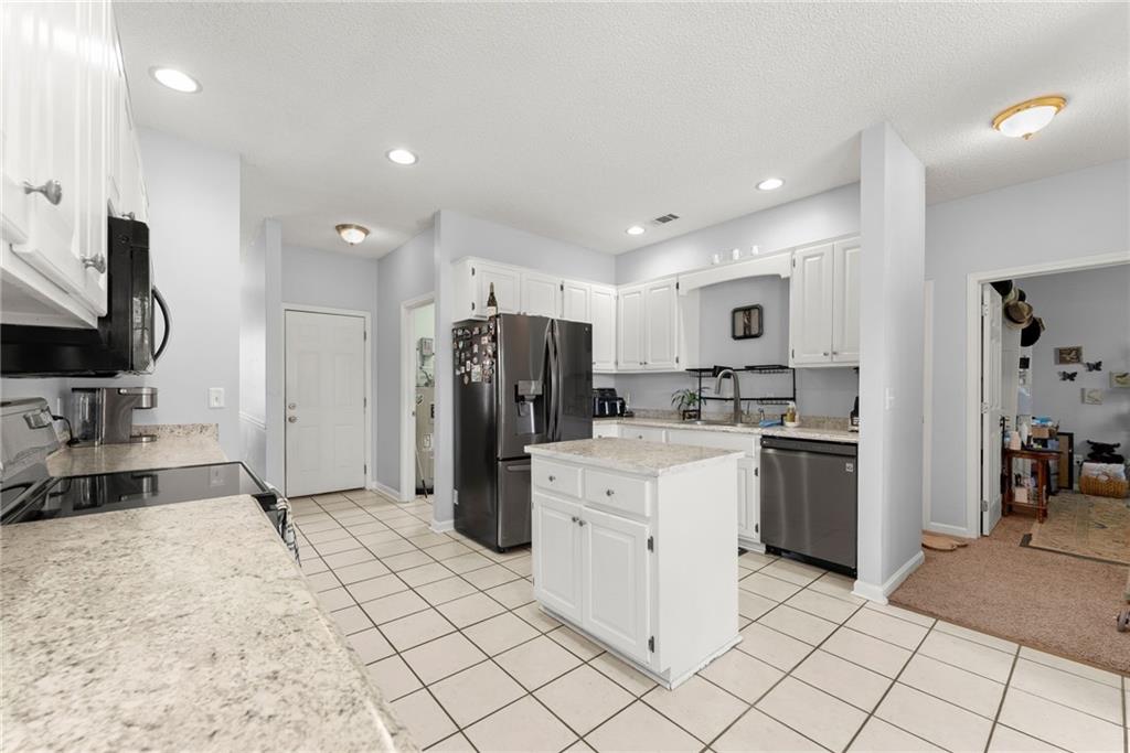 716 Michael Drive Winder, GA 30680 - Photo 15 of 46 a kitchen with refrigerator and cabinets
