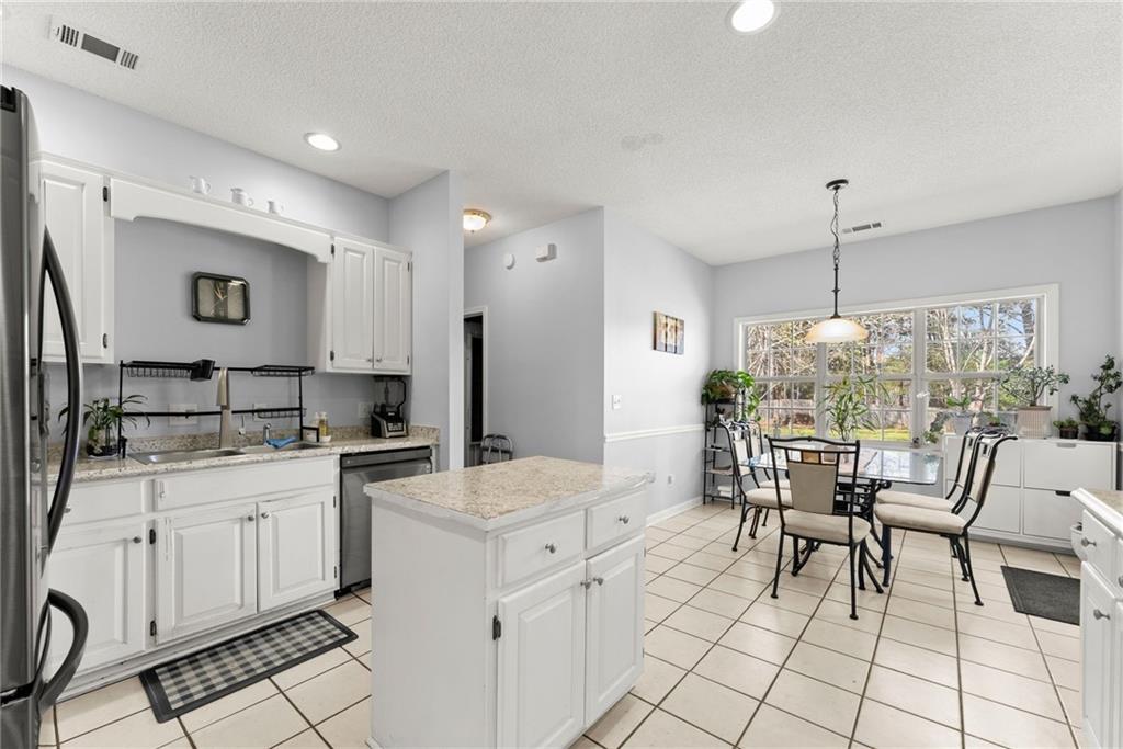 716 Michael Drive Winder, GA 30680 - Photo 16 of 46 a kitchen with a dining table chairs and white appliances