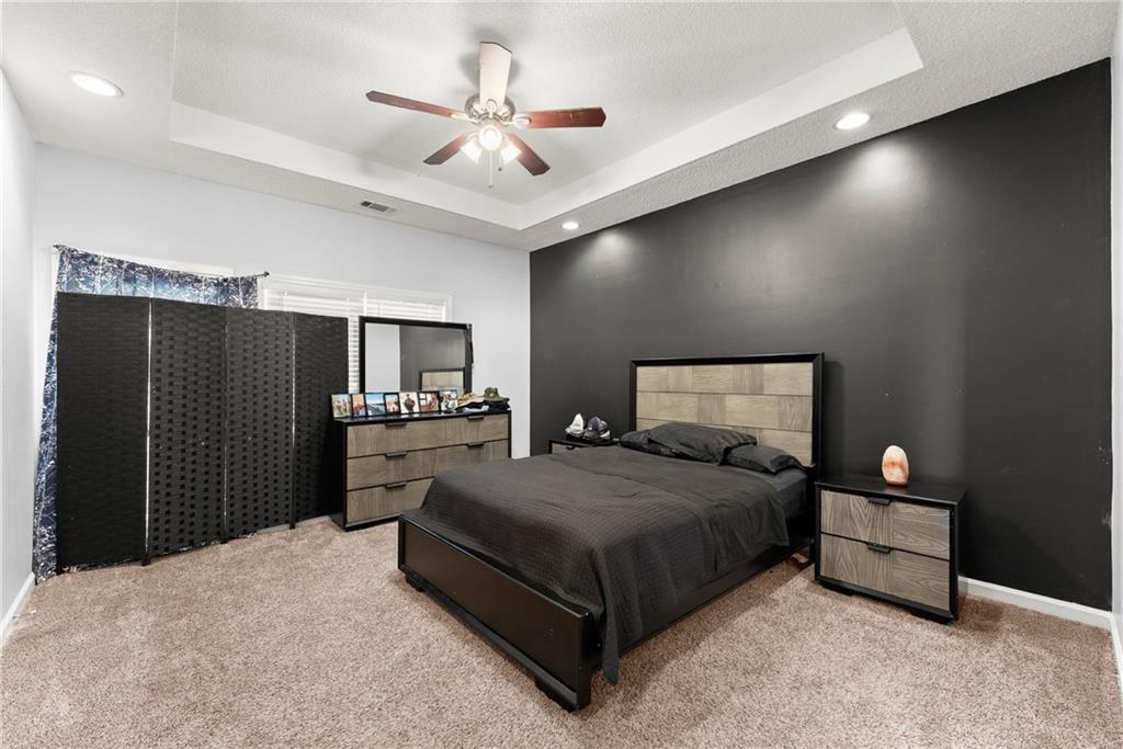716 Michael Drive Winder, GA 30680 - Photo 18 of 46 a spacious bedroom with a bed and a chandelier
