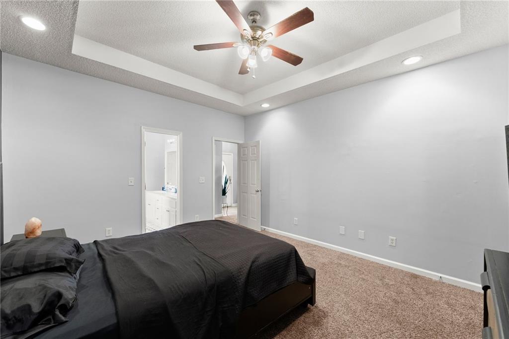 716 Michael Drive Winder, GA 30680 - Photo 20 of 46 a bedroom with a bed and a ceiling fan