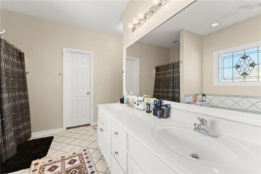 716 Michael Drive Winder, GA 30680 - Photo 22 of 46 a bathroom with double vanity and a mirror