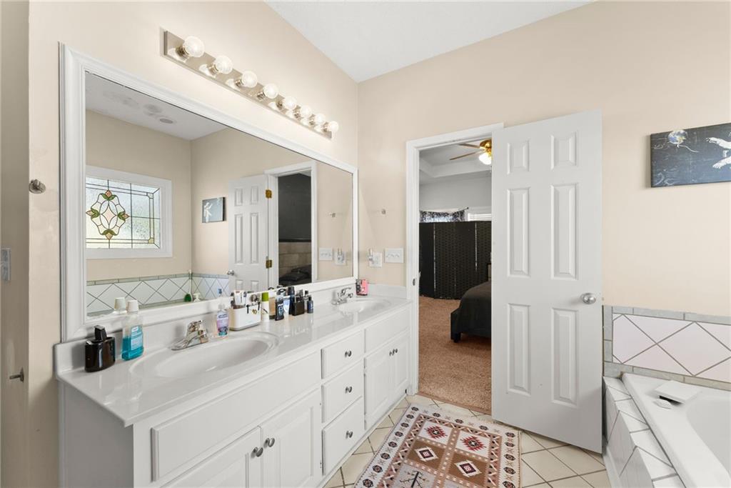716 Michael Drive Winder, GA 30680 - Photo 23 of 46 a bathroom with a double vanity sink and a mirror