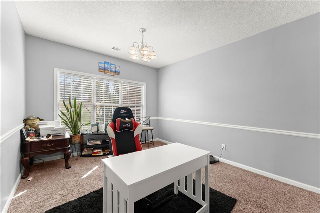716 Michael Drive Winder, GA 30680 - Photo 29 of 46 a living room with furniture a window and a chandelier