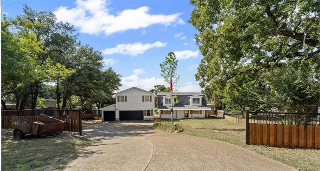 a front view of a house with a garden and tree
