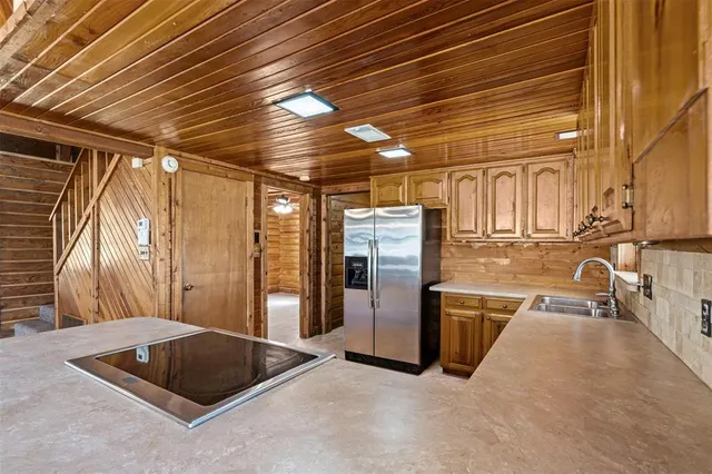 a kitchen with stainless steel appliances granite countertop a sink a stove and refrigerator