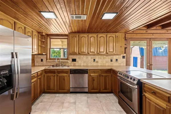 a kitchen with stainless steel appliances granite countertop a sink a stove and refrigerator