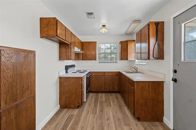 a view of a kitchen with a refrigerator a ceiling fan and wooden floor