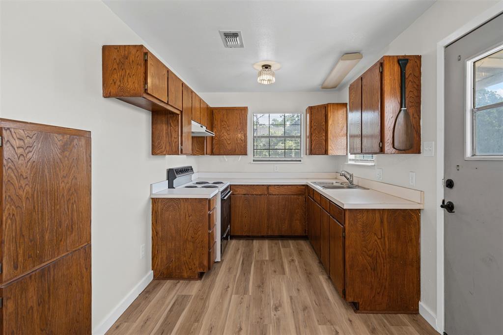 7329 Hickey Road Azle, TX 76020 - Photo 23 of 28 a kitchen with stainless steel appliances granite countertop a sink stove and wooden cabinets