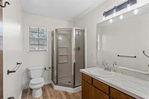 a bathroom with a sink a toilet and shower