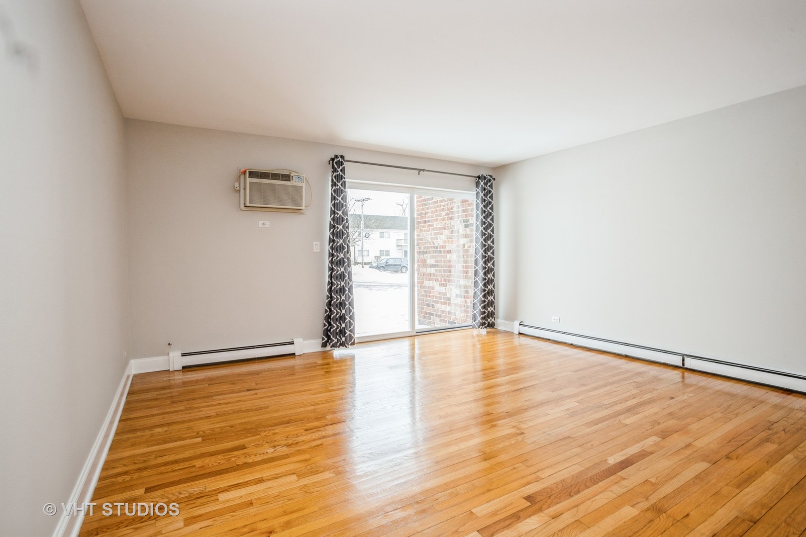 850 South Lorraine Road, Unit 1E Wheaton, IL 60189 - Photo 5 of 15 a view of an empty room with wooden floor and a window