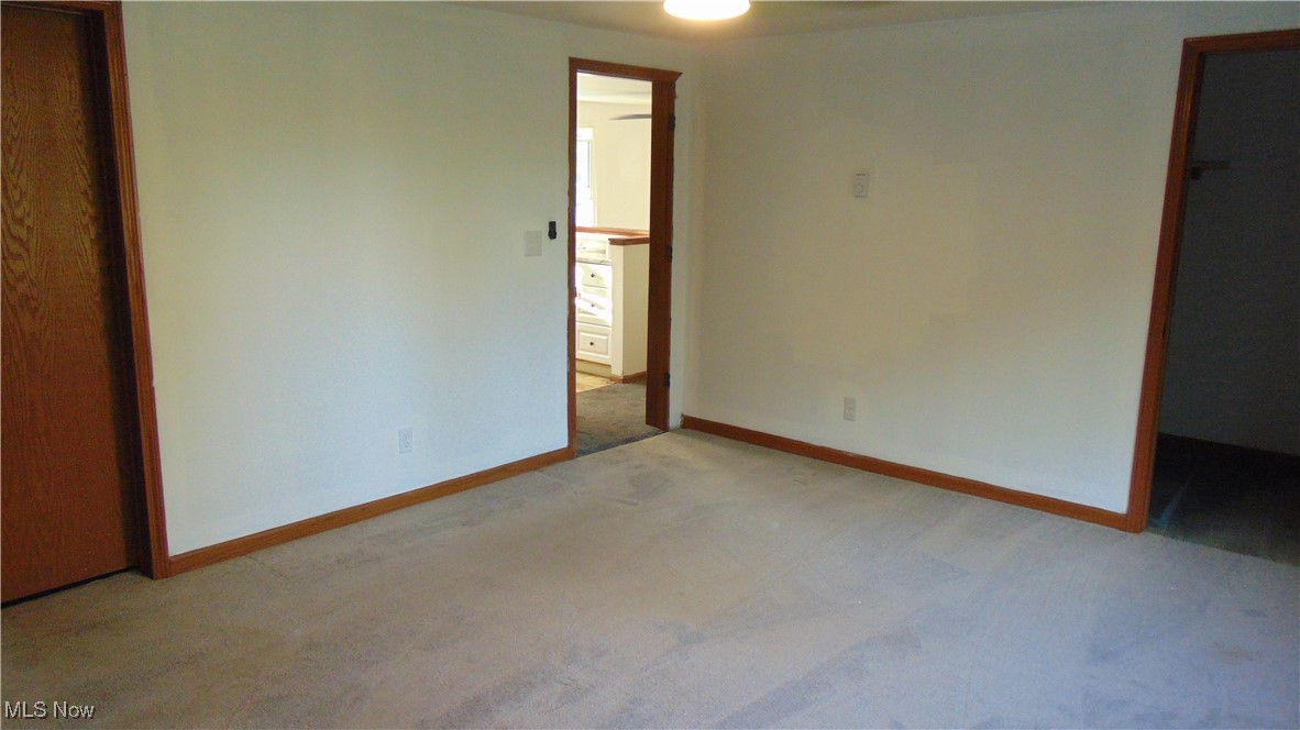 4970 Bryenton Road Litchfield, OH 44253 - Photo 16 of 33 Unfurnished bedroom featuring light carpet, a walk in closet, and a ceiling fan