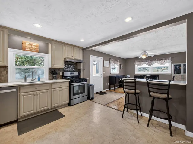 a kitchen with stainless steel appliances granite countertop a refrigerator sink and stove
