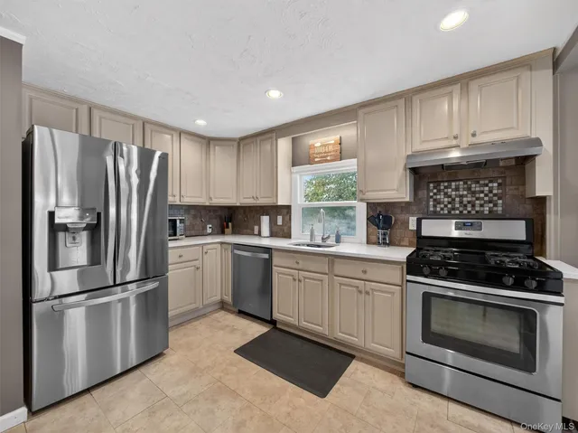 a kitchen with stainless steel appliances a refrigerator and wooden cabinets