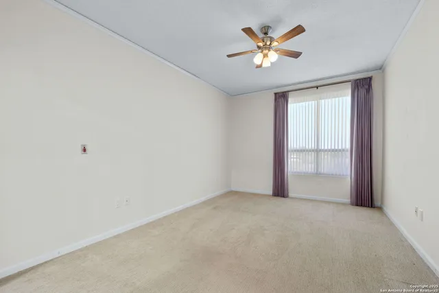 an empty room with closet and ceiling fan