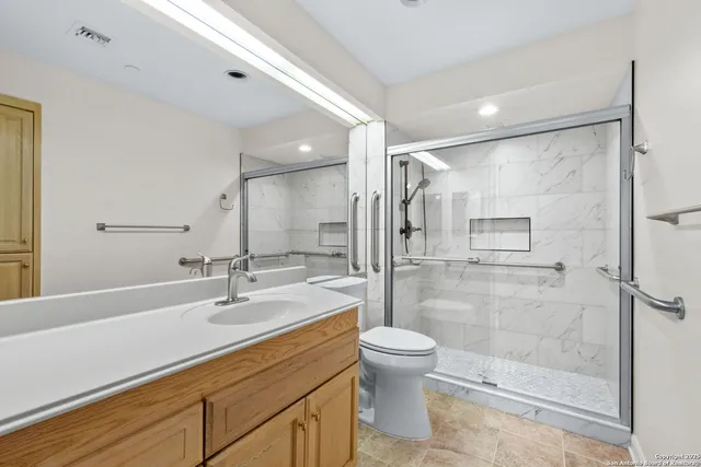 a bathroom with a shower sink vanity mirror and toilet