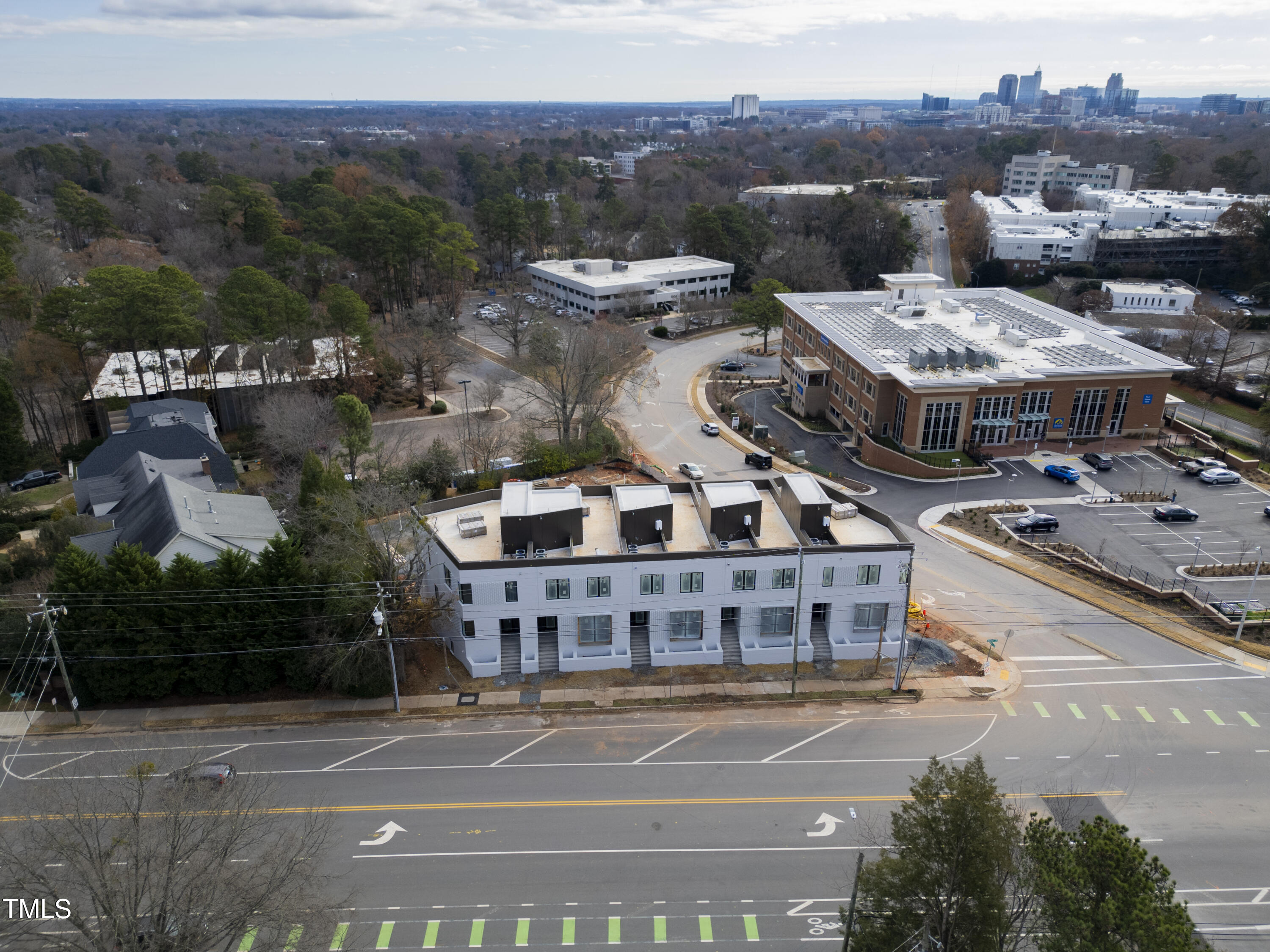 1310 Chamblee Hill Raleigh, NC 27608 - Photo 2 of 26 a aerial view of a large building with a mountain in the background