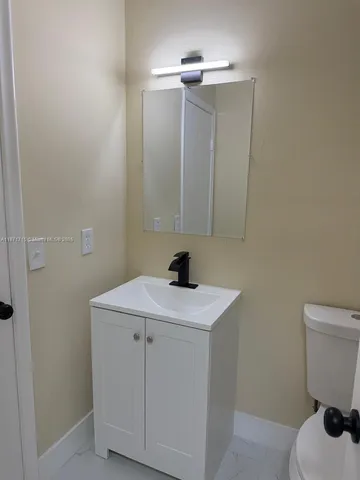 a bathroom with a sink a toilet and mirror