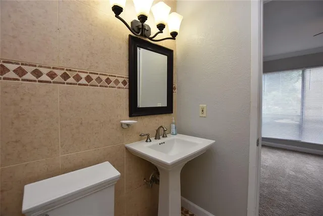 a bathroom with a sink a toilet and mirror