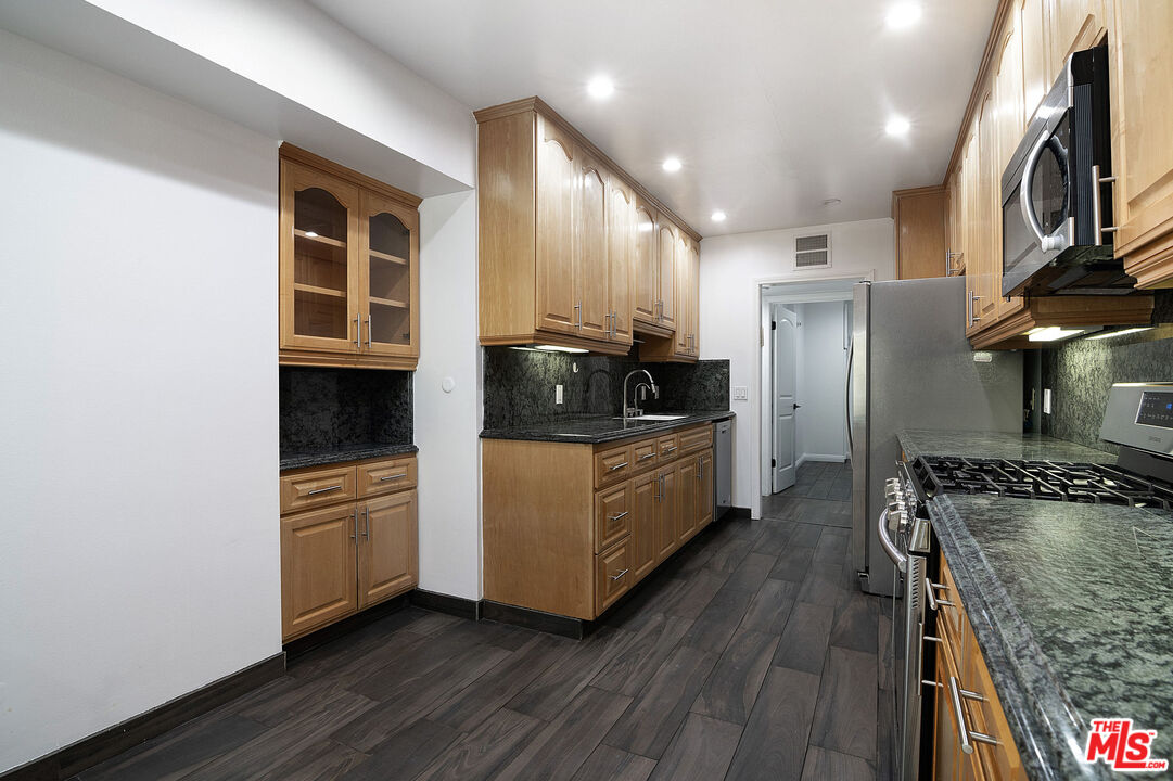 853 Le Doux Road, Unit 201 Los Angeles, CA 90035 - Photo 15 of 36 a kitchen with stainless steel appliances granite countertop a stove a refrigerator and a microwave