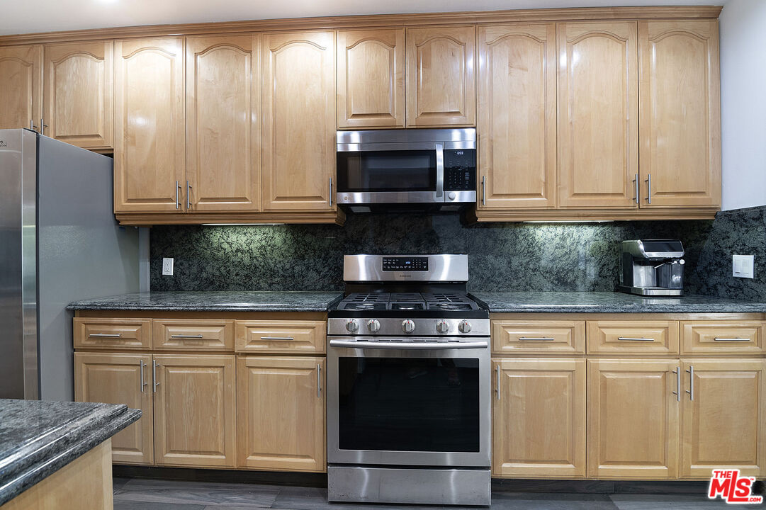 853 Le Doux Road, Unit 201 Los Angeles, CA 90035 - Photo 16 of 36 a kitchen with granite countertop cabinets stainless steel appliances and a wooden floor