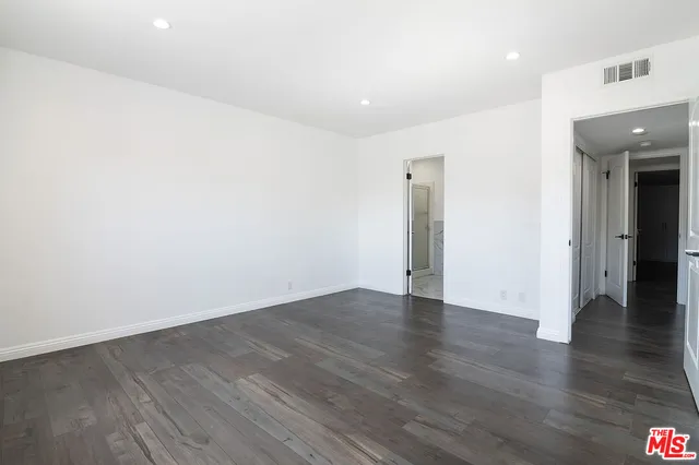 an empty room with wooden floor and a painting