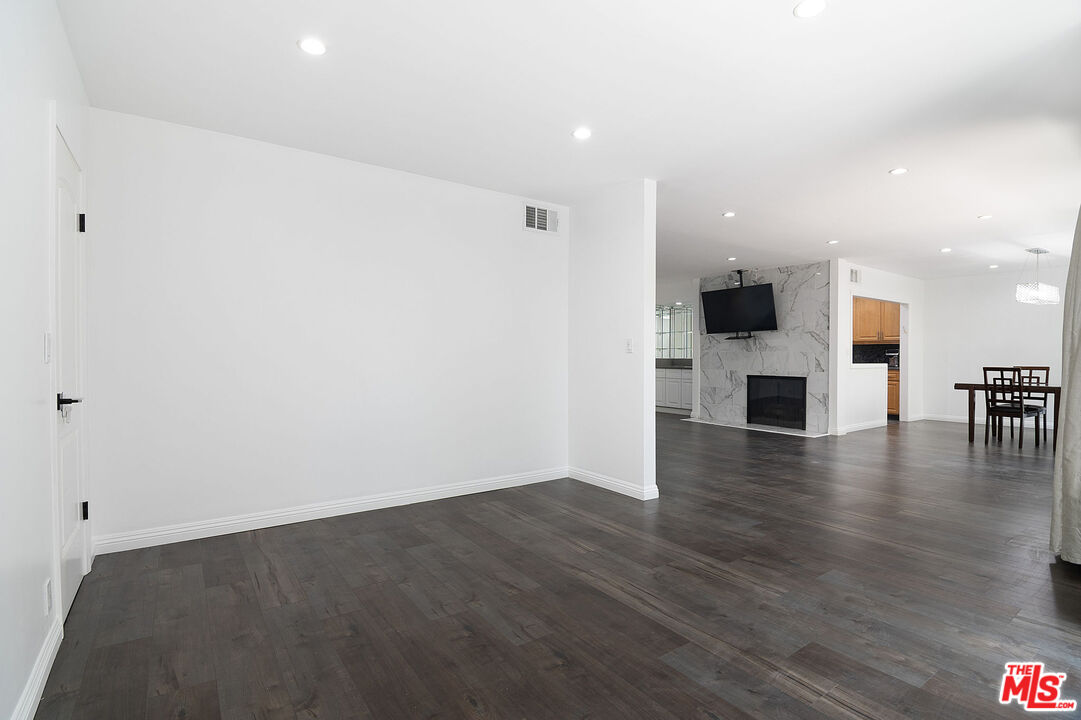 853 Le Doux Road, Unit 201 Los Angeles, CA 90035 - Photo 8 of 36 an empty room with wooden floor and a fireplace