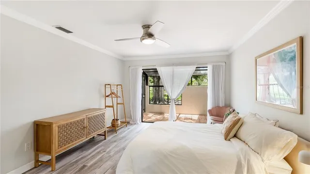 a bedroom with a bed wooden floor and window