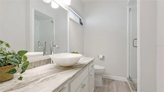 a bathroom with a granite countertop sink a toilet and a mirror