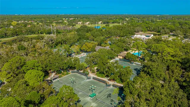 an aerial view of residential houses with outdoor space and trees