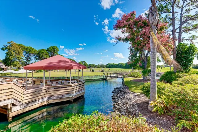 a view of a swimming pool with lawn chairs under an umbrella