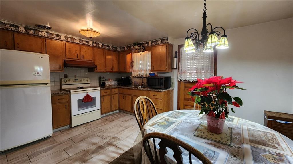 262 Vista Drive Apollo, PA 15613 - Photo 11 of 23 a kitchen with stainless steel appliances granite countertop a sink refrigerator dining table and chairs