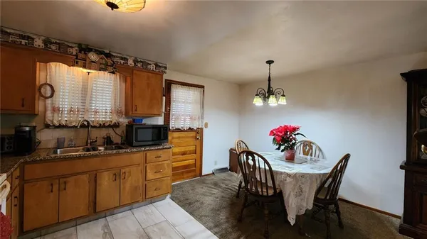 a kitchen with stainless steel appliances granite countertop a sink refrigerator dining table and chairs