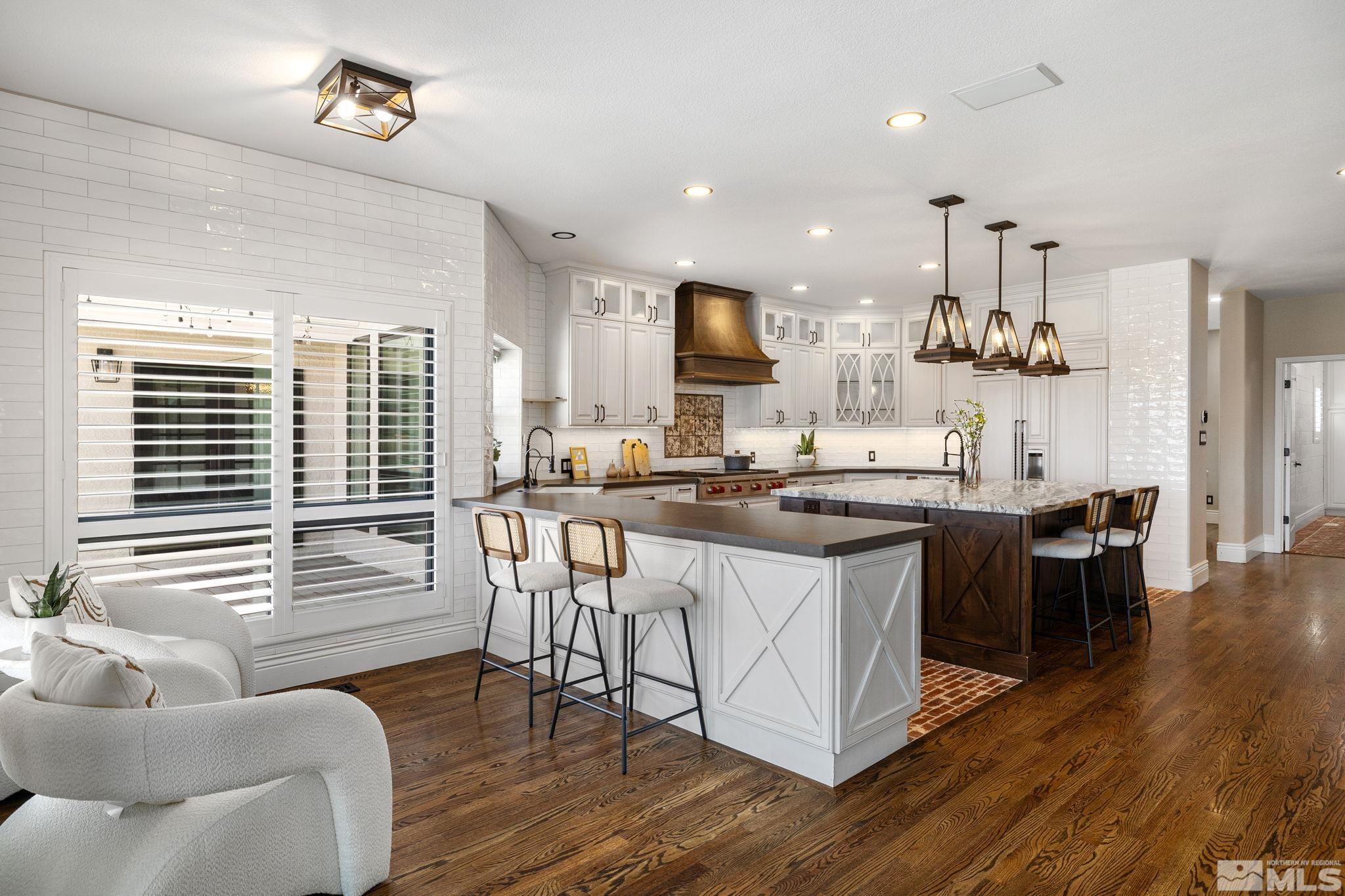 12595 Water Lily Way Reno, NV 89511 - Photo 11 of 36 a kitchen with stainless steel appliances granite countertop a stove a sink dishwasher and a dining table with wooden floor