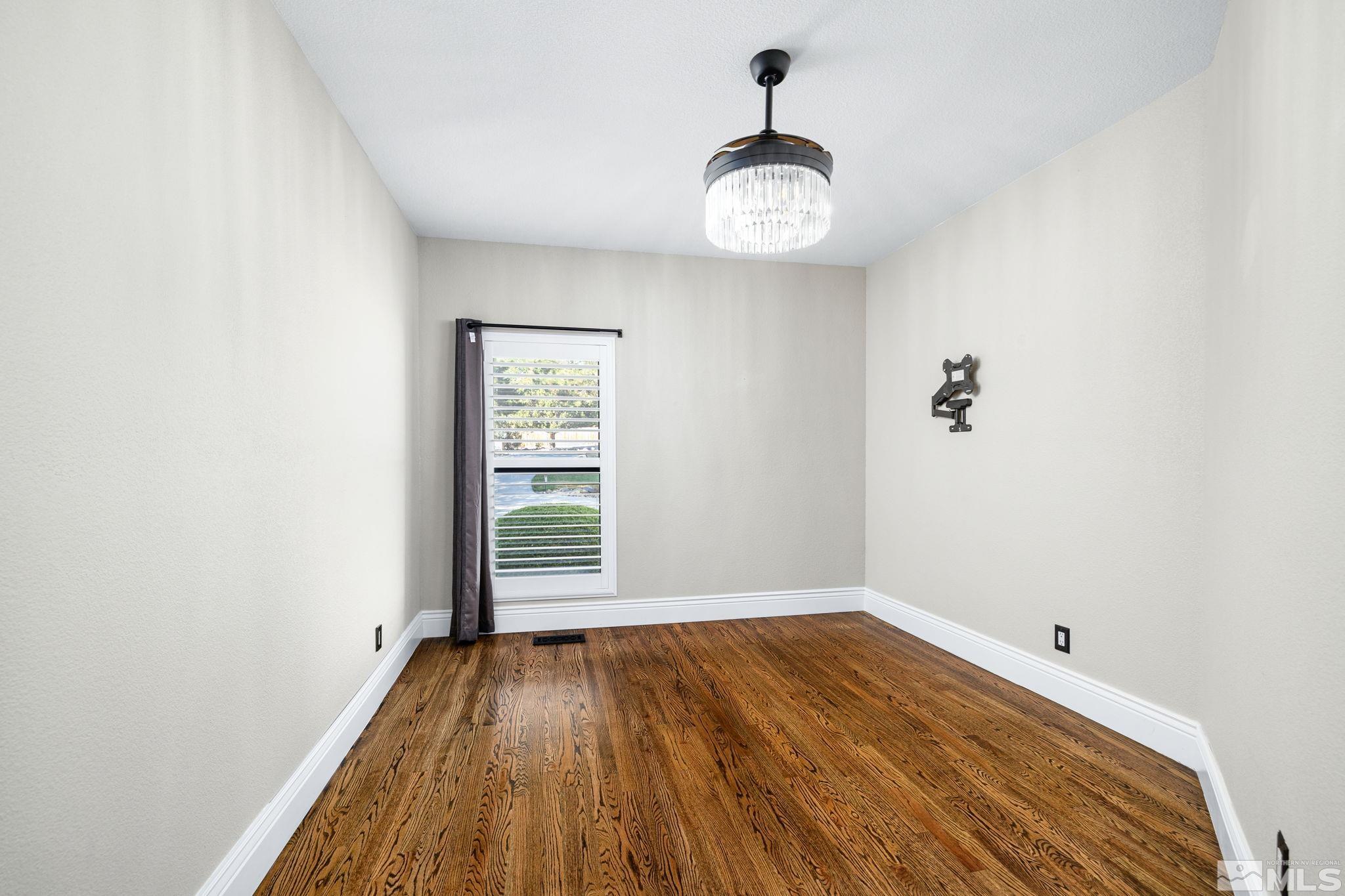 12595 Water Lily Way Reno, NV 89511 - Photo 22 of 36 a view of empty room with wooden floor and fan