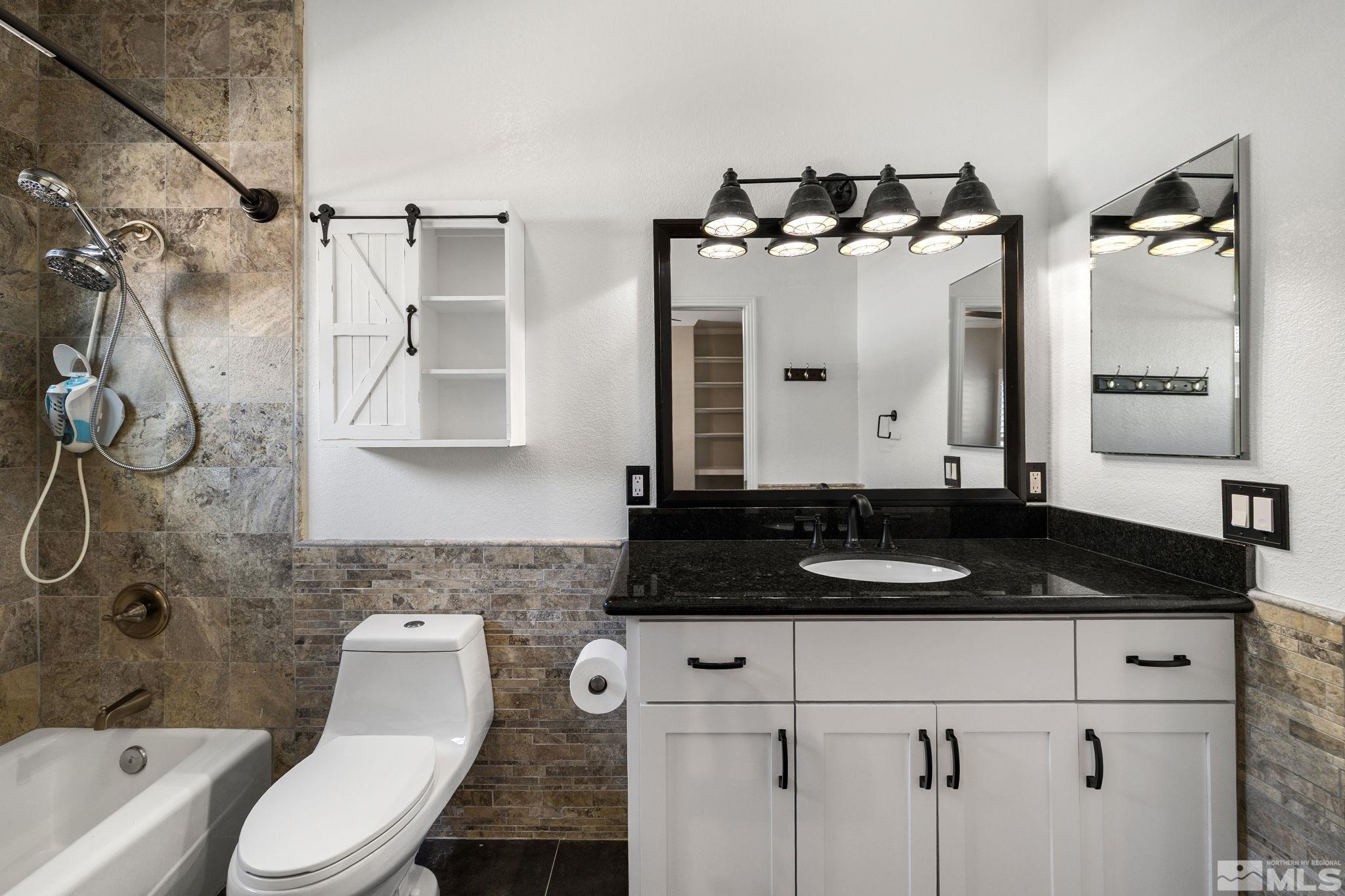 12595 Water Lily Way Reno, NV 89511 - Photo 25 of 36 a bathroom with a granite countertop sink and a mirror