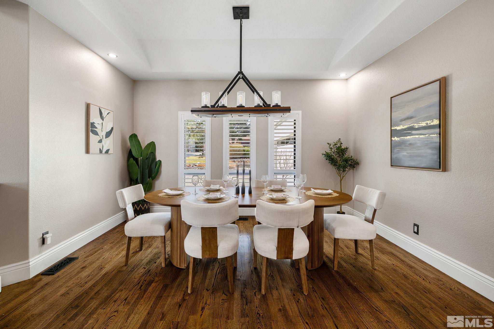 12595 Water Lily Way Reno, NV 89511 - Photo 8 of 36 a dining room with wooden floor a chandelier a glass table and chairs