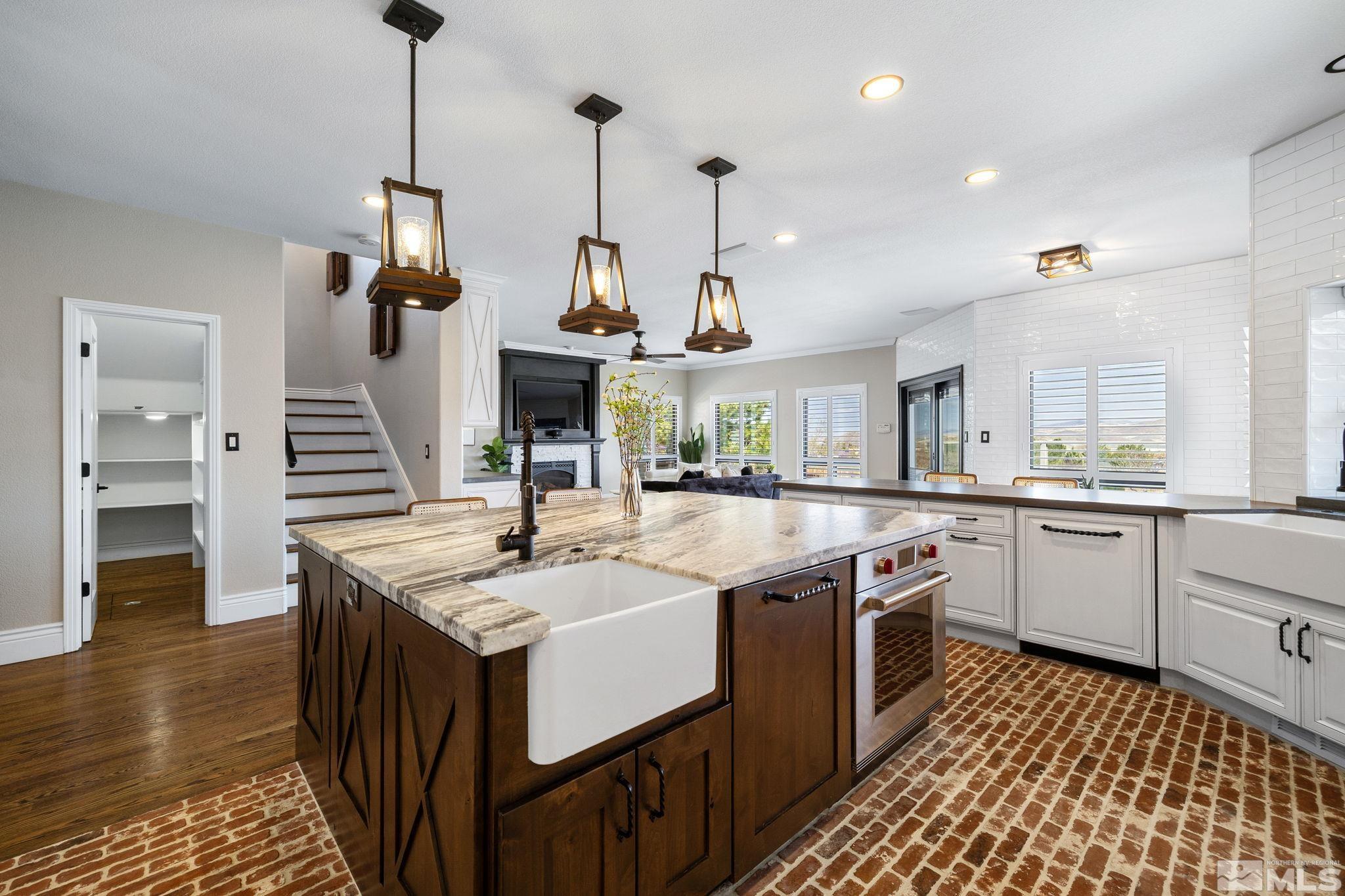 12595 Water Lily Way Reno, NV 89511 - Photo 9 of 36 a kitchen with stainless steel appliances granite countertop a sink and a wooden floor