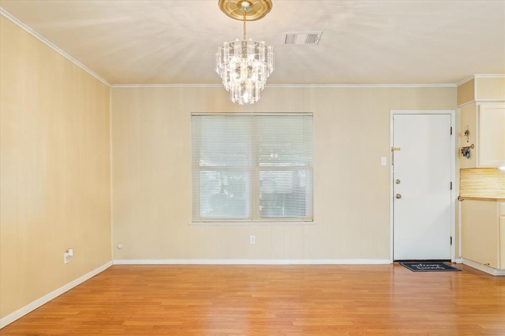 6209 May Drive Waco, TX 76710 - Photo 11 of 30 Unfurnished dining area with light wood-style flooring, crown molding, and a chandelier