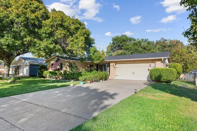 a front view of a house with a yard and a garage