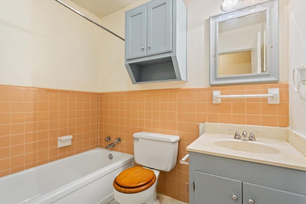 6209 May Drive Waco, TX 76710 - Photo 22 of 30 Bathroom with tile walls, vanity, a wainscoted wall, and bathing tub / shower combination