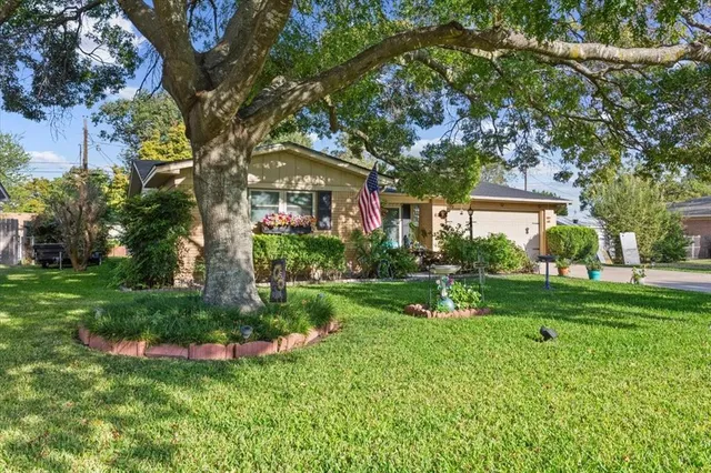a view of a house with a big yard and large trees