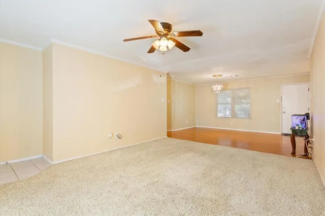 an empty room with a ceiling fan and a window