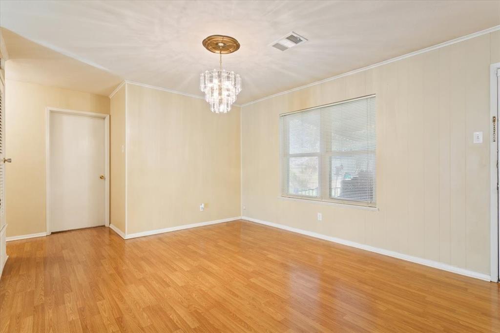 6209 May Drive Waco, TX 76710 - Photo 10 of 30 Spare room with light wood finished floors, a chandelier, and ornamental molding