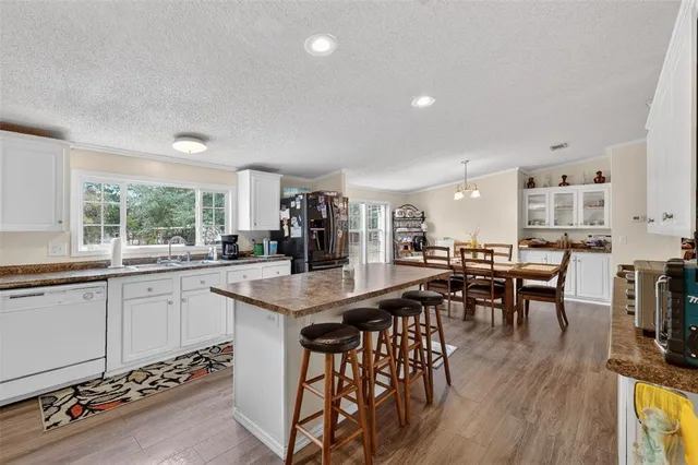 a kitchen with stainless steel appliances granite countertop a table and chairs in it