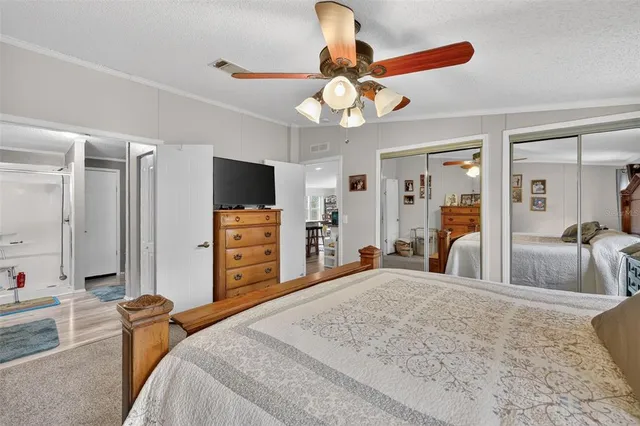 a bedroom with a bed and a flat tv screen on dresser