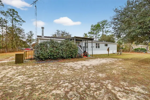 a front view of a house with a yard and potted plants
