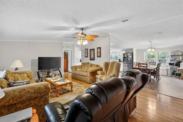 a living room with furniture kitchen view and a flat screen tv