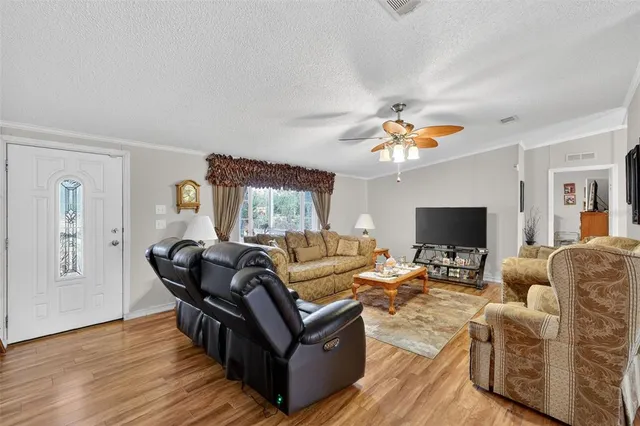 a living room with furniture and a flat screen tv with wooden floor