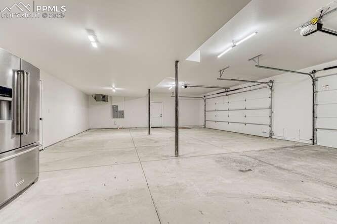 1282 South Crystal Road Lake George, CO 80827 - Photo 17 of 26 Garage with high end fridge, a garage door opener, and a heating unit